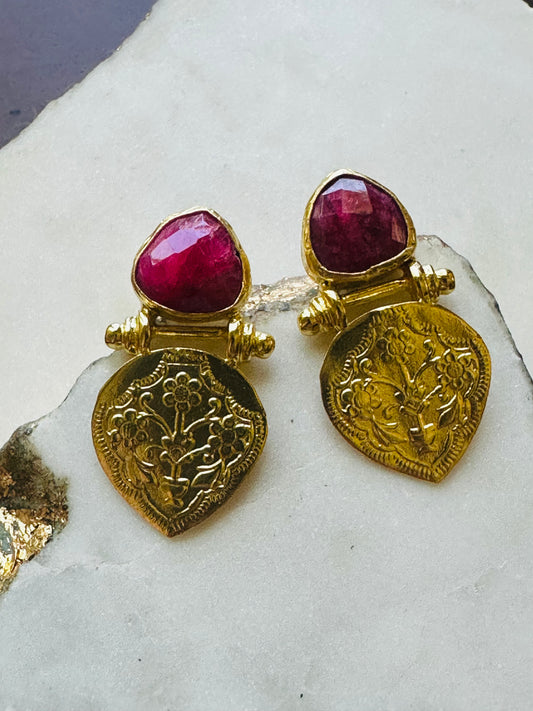 Handmade Gold-plated Ruby stud earrings on a white stone background