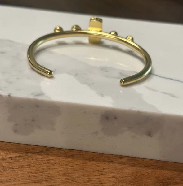 Back of Gold-plated lapis lazuli bangle on a marble surface