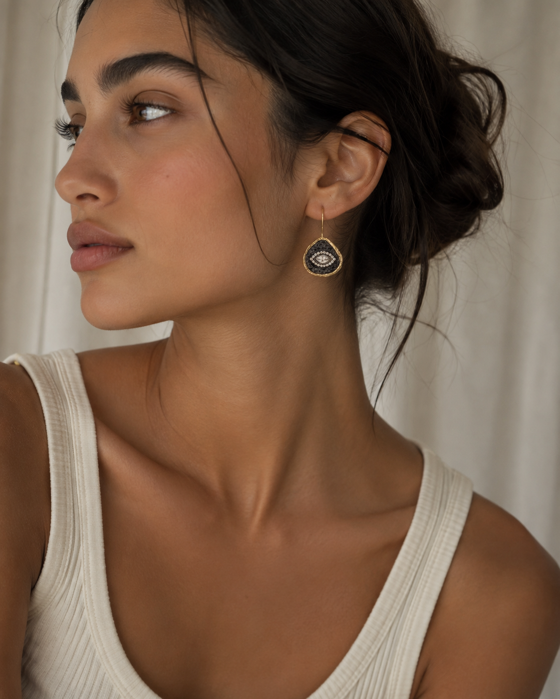 Model wearing Artisanal Handmade gold-plated contemporary silver and cz evil eye earrings 