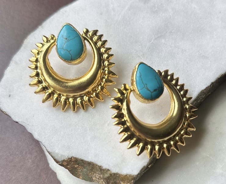 Handmade suitable gold-plated turquoise statement stud earrings on white surface 
