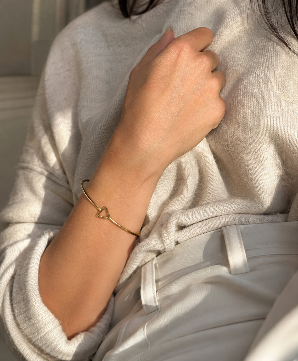 Close up of Handmade sustainable anti-tarnish gold-plated dainty triangle bracelet on model in Aritzia clothing  