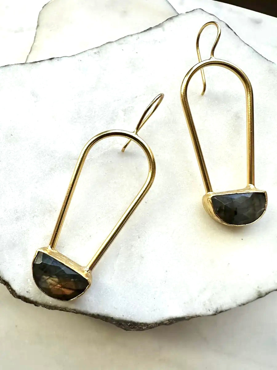 Handmade Gold-plated earrings with labradorite gemstones on a white stone surface
