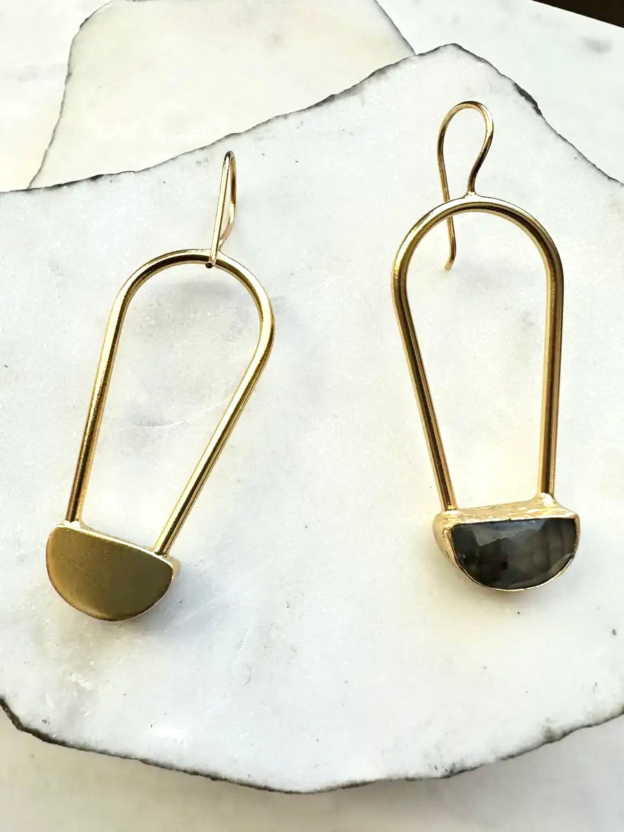 Artisanal Gold-plated geometric earrings with labradorite stones on a white stone