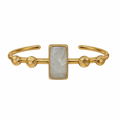 Gold cuff bracelet featuring a rectangular faceted light gray labradorite gemstone in the center and four textured gold ball accents on each side of the stone, on a plain white background.