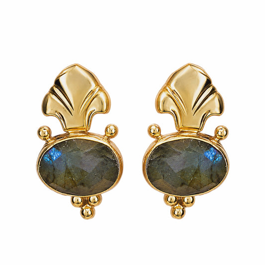 A pair of Fleur de lis gold stud earrings featuring oval labradorite stones in gray green, on a plain white background.