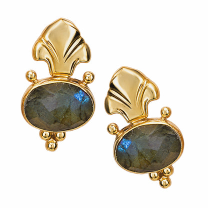 A pair of Fleur de lis gold stud earrings featuring oval labradorite stones in gray green on a plain white background