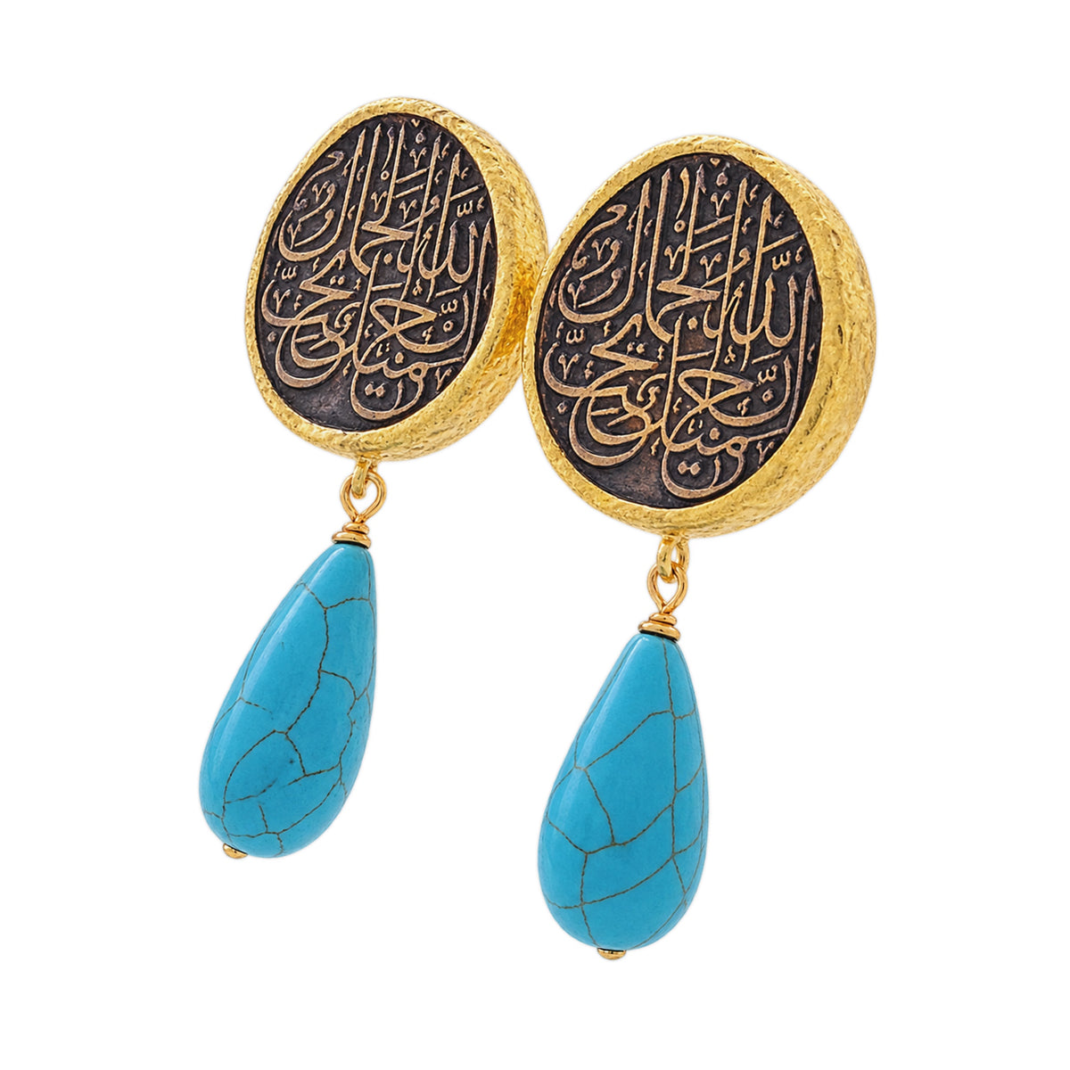 A pair of gold and black drop earrings featuring circular studs with Arabic calligraphy and dangling turquoise on a white background facing left