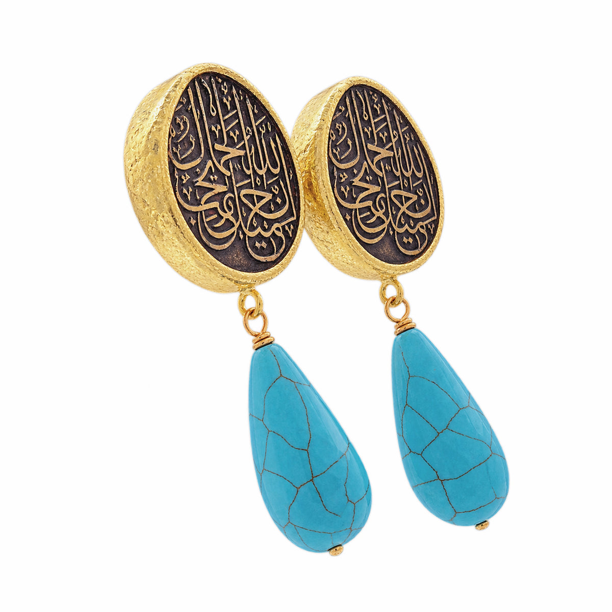 A pair of gold and black drop earrings featuring circular studs with Arabic calligraphy and dangling turquoise on a white background facing right