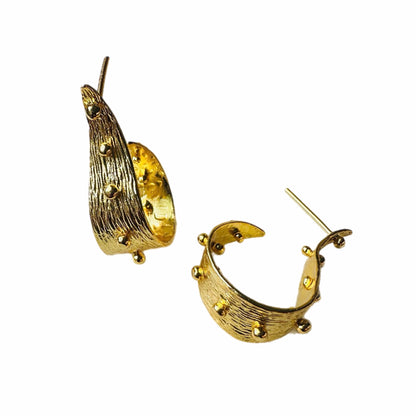 A pair of textured contemporary gold hoop earrings with small raised gold ball accents, on a plain white background.
