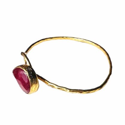 Artisanal Gold-plated hammer-finished bracelet with red ruby gemstone on a white surface