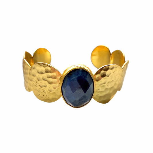 Gold-plated artisanal bracelet with a central blue lapis lazuli gemstone on a white background