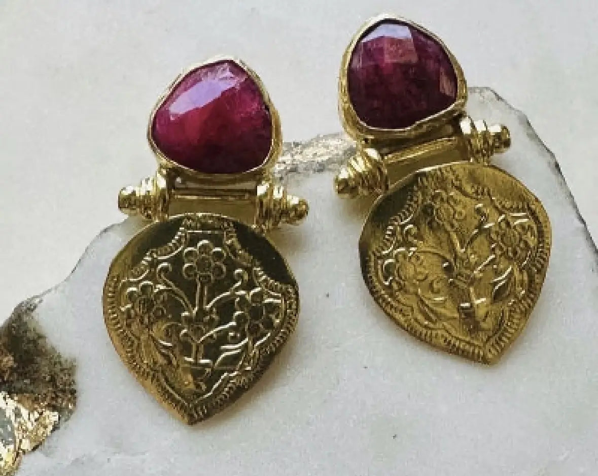 High quality artisanal Gold-plated ruby stud earrings with etchings on a white background