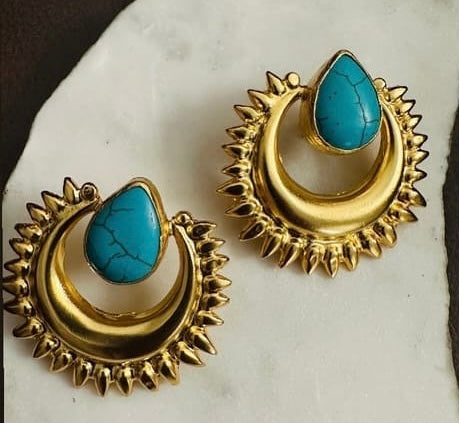 Handmade sustainable Gold-plated statement earrings with turquoise stones on a marble surface