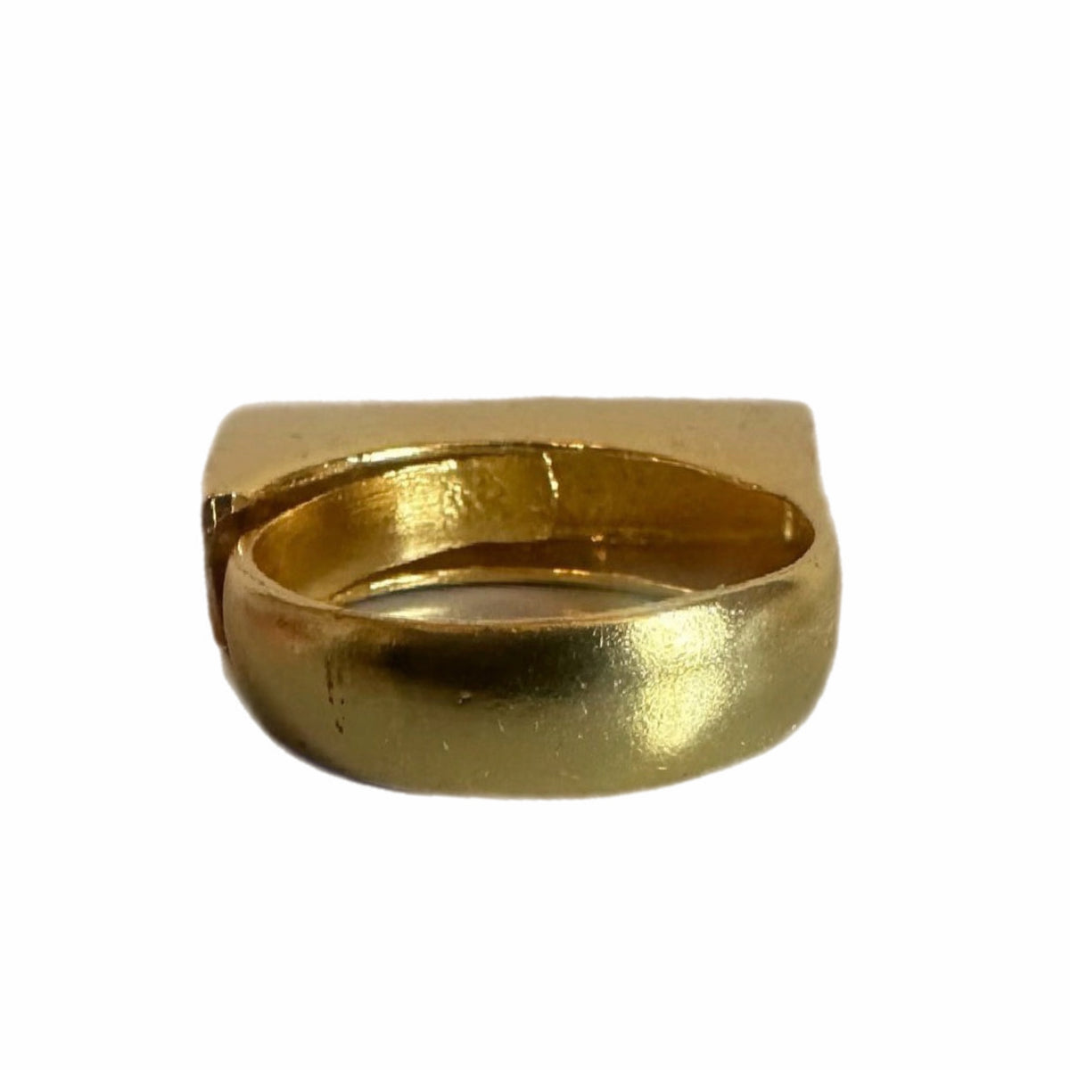 Back side of A gold-plated bar ring with Arabic calligraphy engraved on it, displayed on a white surface.