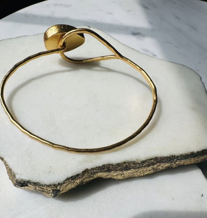 Back of Gold-plated bracelet on a white stone surface