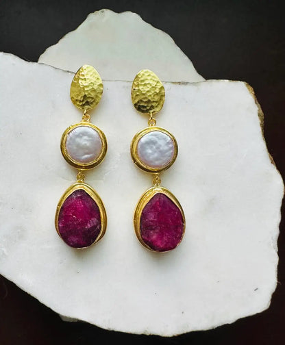 Beautiful handmade sustainable gold-plated ruby and flat pearl dangle earrings on white marble 