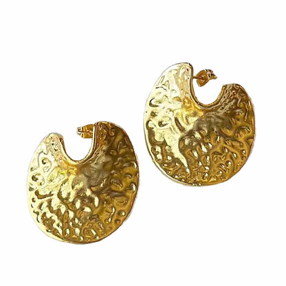A pair of textured gold crescent-shaped contemporary hoop earrings on a plain white background.