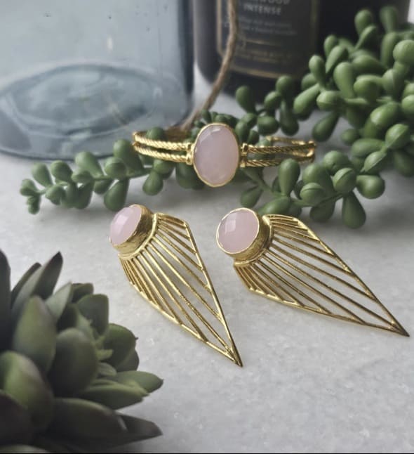 Artisanal sustainable Gold-plated bold earrings with pink rose quartz gemstones on a surface with greenery