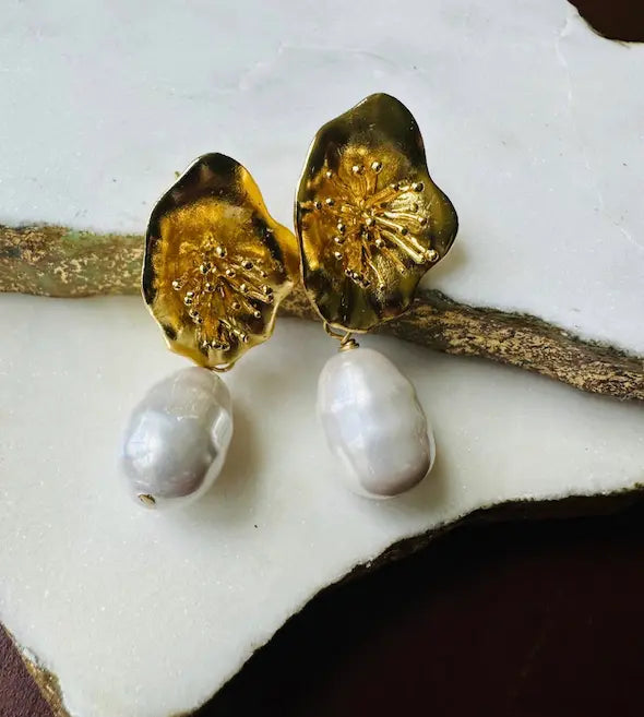 Handmade eco-friendly Parisian-inspired gold-plated gold flower and baroque pearl earrings on a white surface