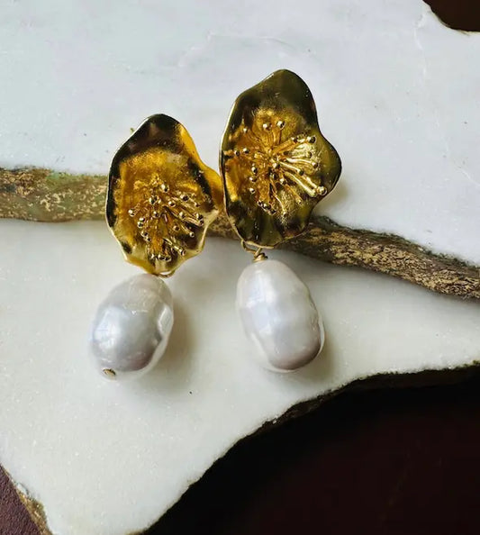 Handmade eco-friendly Parisian-inspired gold-plated gold flower and baroque pearl earrings on a white surface