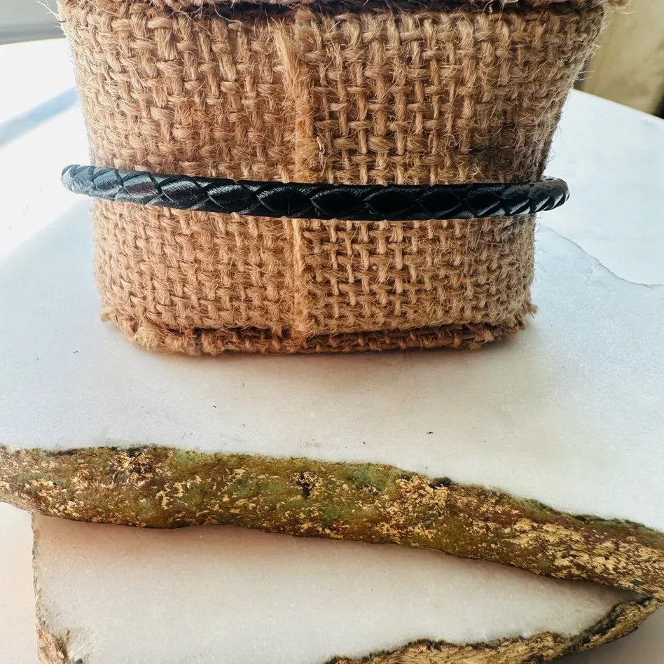 Handmade Braided black leather bracelet on a woven burlap 