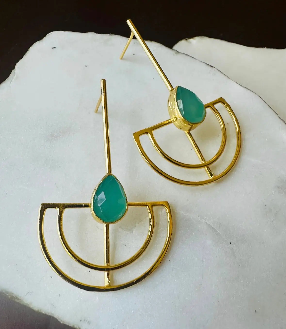 Gold-plated artisanal sustainable contemporary long aqua chalcedony earrings on a white stone surface