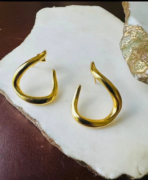 Handmade eco-friendly abstract Gold-plated hoop earrings on a white stone surface