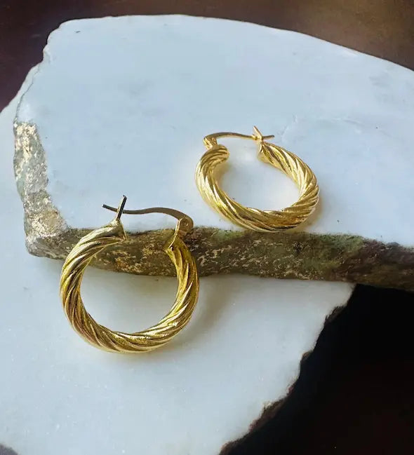 Who-friendly waterproof Artisanal Gold-plated etched hoop earrings on a white stone surface