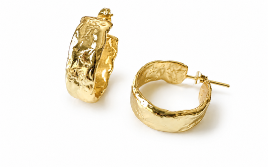 A pair of textured gold-played hoop earrings with a hammered finish, displayed on a clean white background