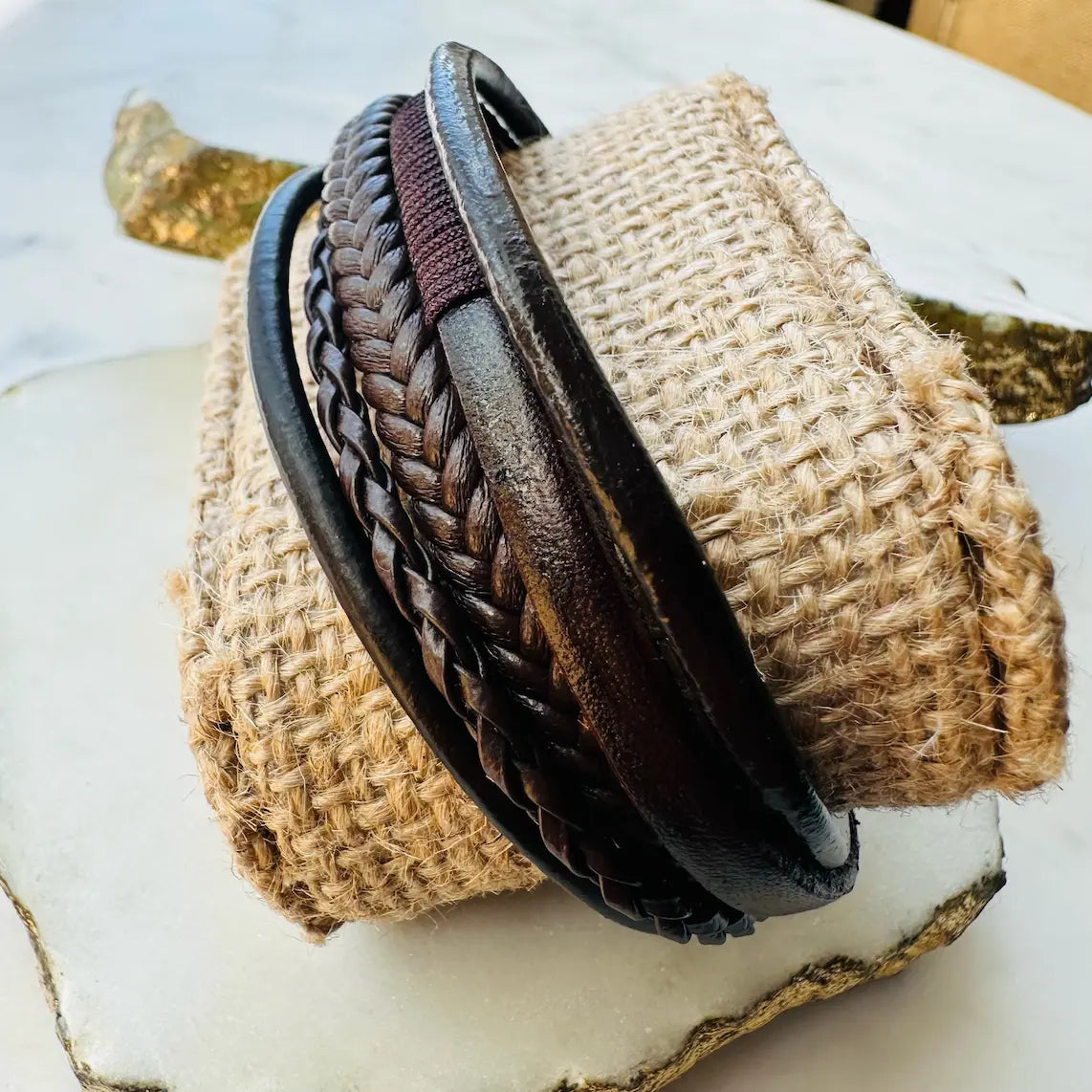 Men’s boho rugged Handmade brown braided leather Stack bracelet on a textured surface