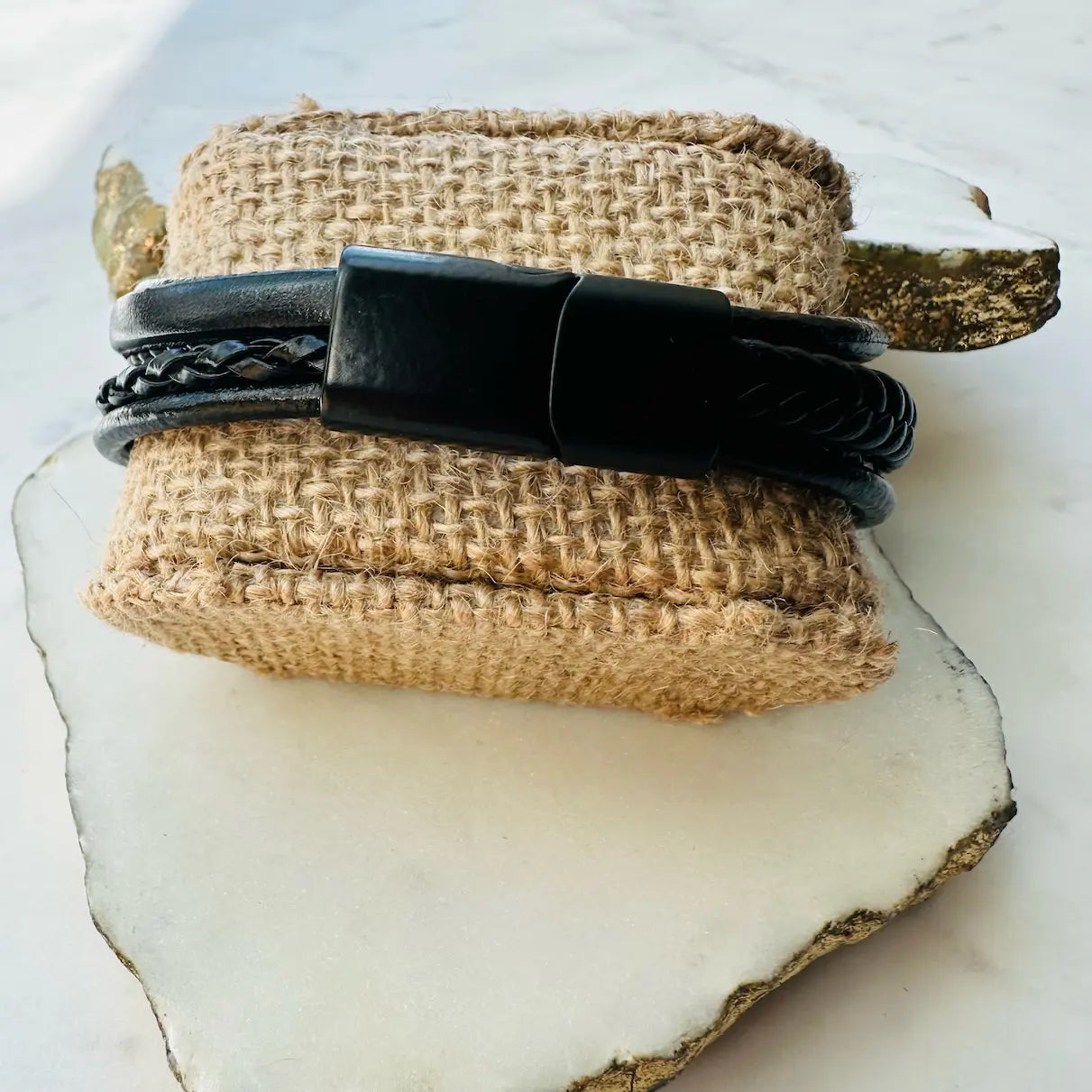 Handmade men’s boho stylish Black multi-strand leather cuff bracelet on a textured beige stone