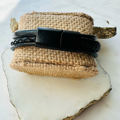Handmade men’s boho stylish Black multi-strand leather cuff bracelet on a textured beige stone