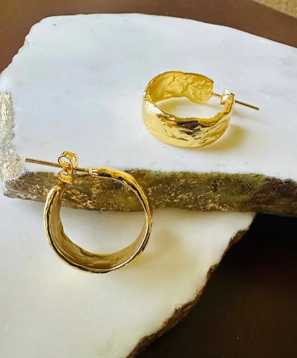 handmade Gold-plated textured thick hoop earrings on a white stone surface