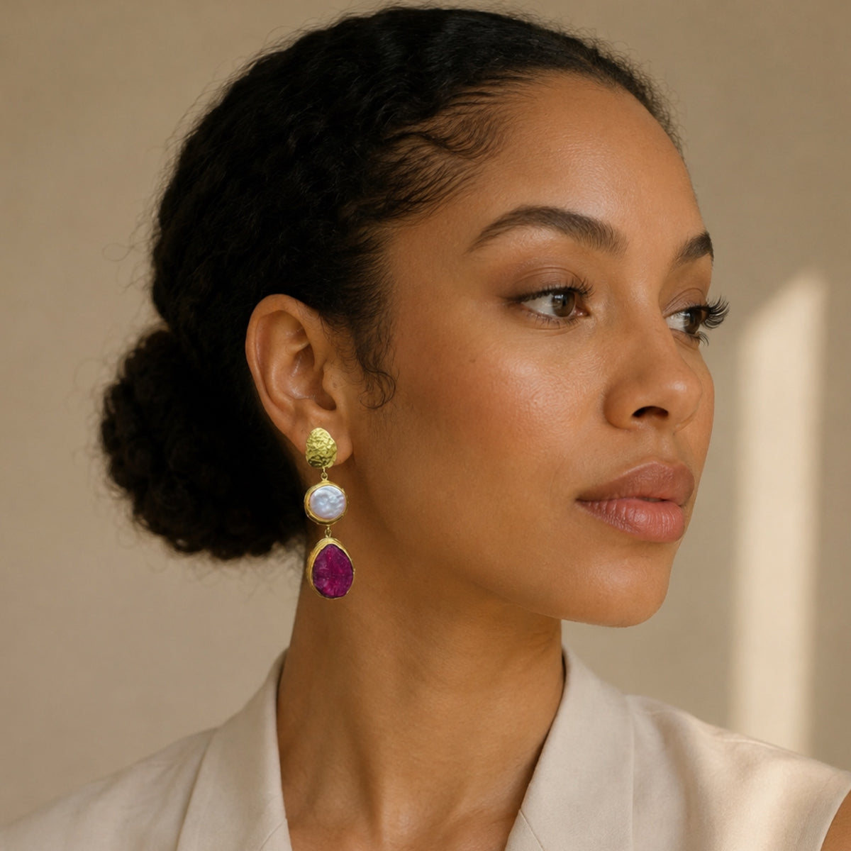Black Model wearing beige top and stunning handmade gold-plated ruby and flat pearl dangle earrings 