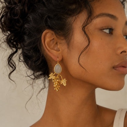 Close-up-model-wearing-hold-grapes-on-vines-snow-quartz-statement-earrings-with-artisan-top