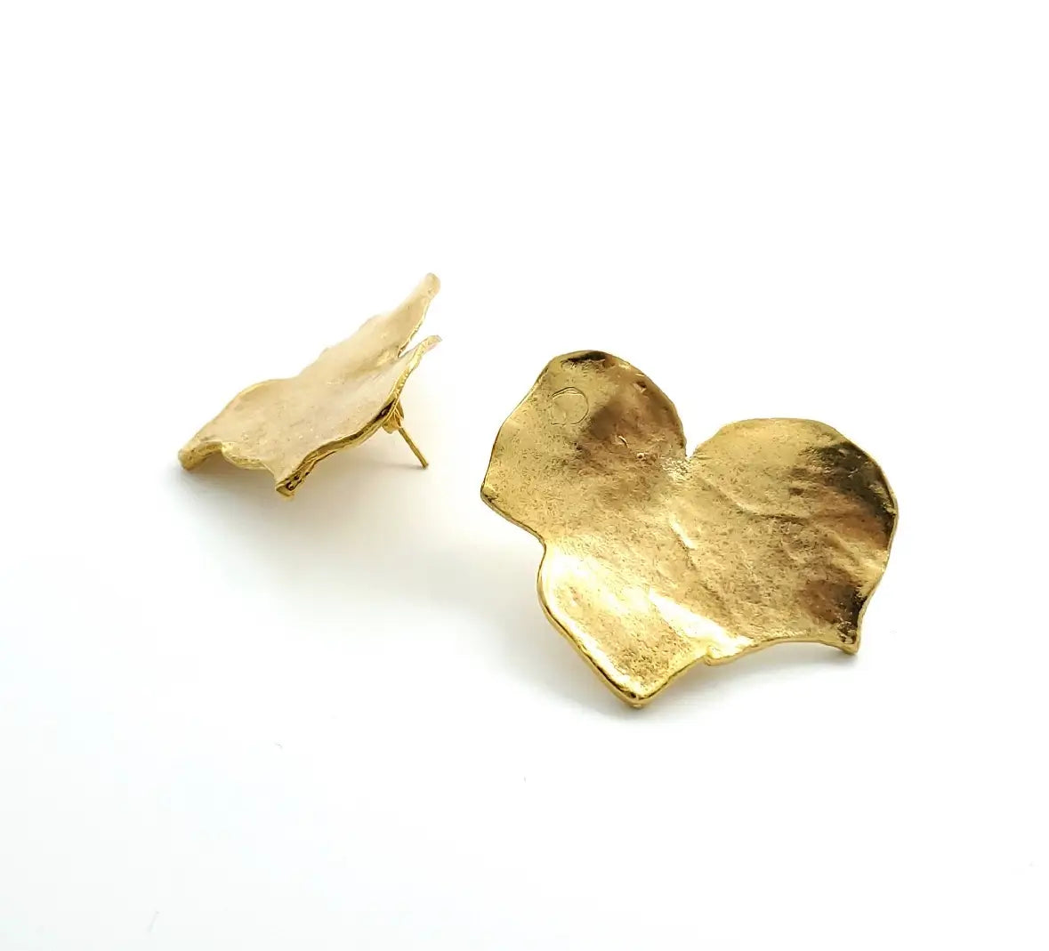 Close-up of contemporary handmade sustainable gold-plated bold leaf earrings 