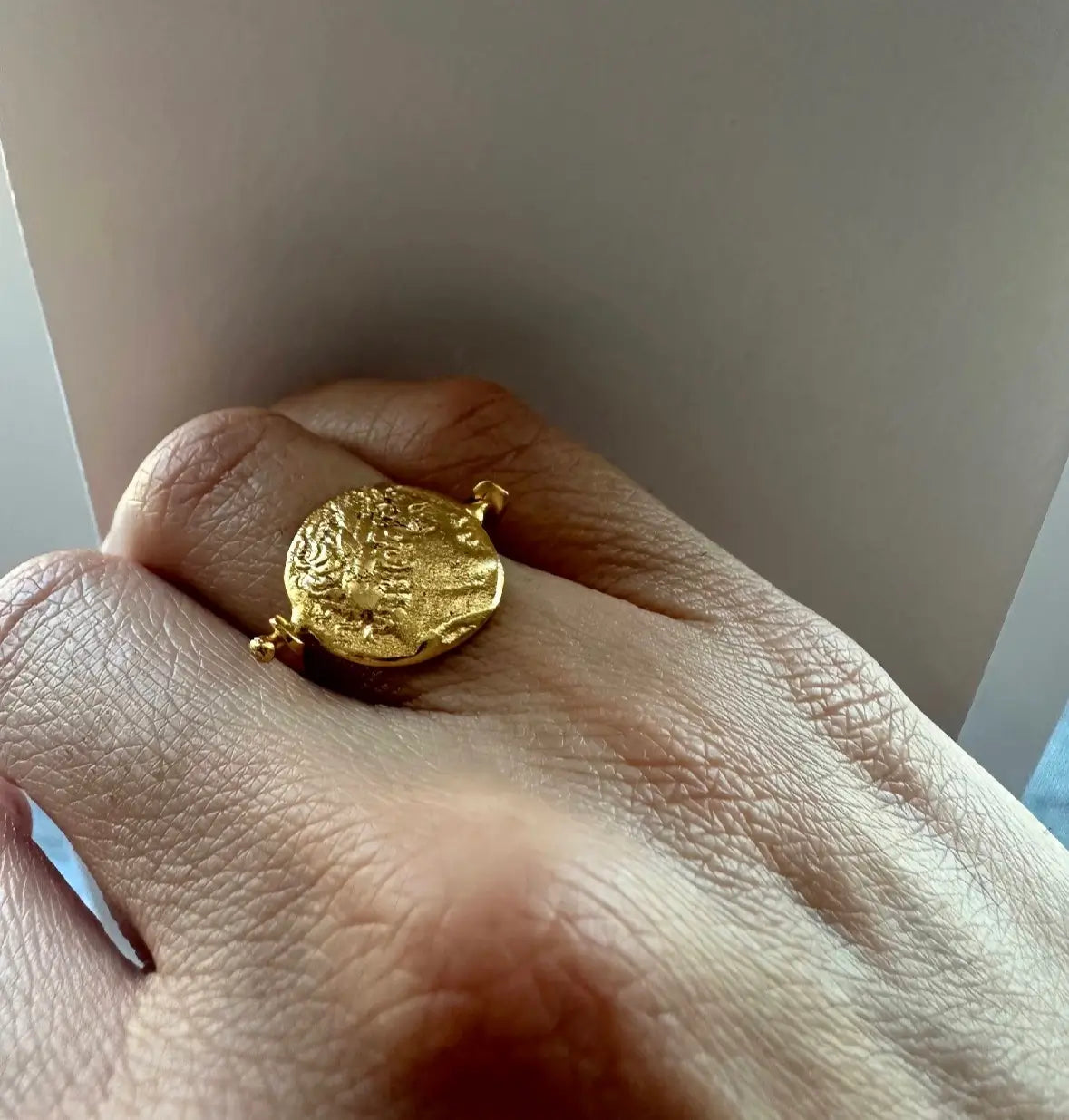 Close up of waterproof sustainable gold-plated flip coin Ring