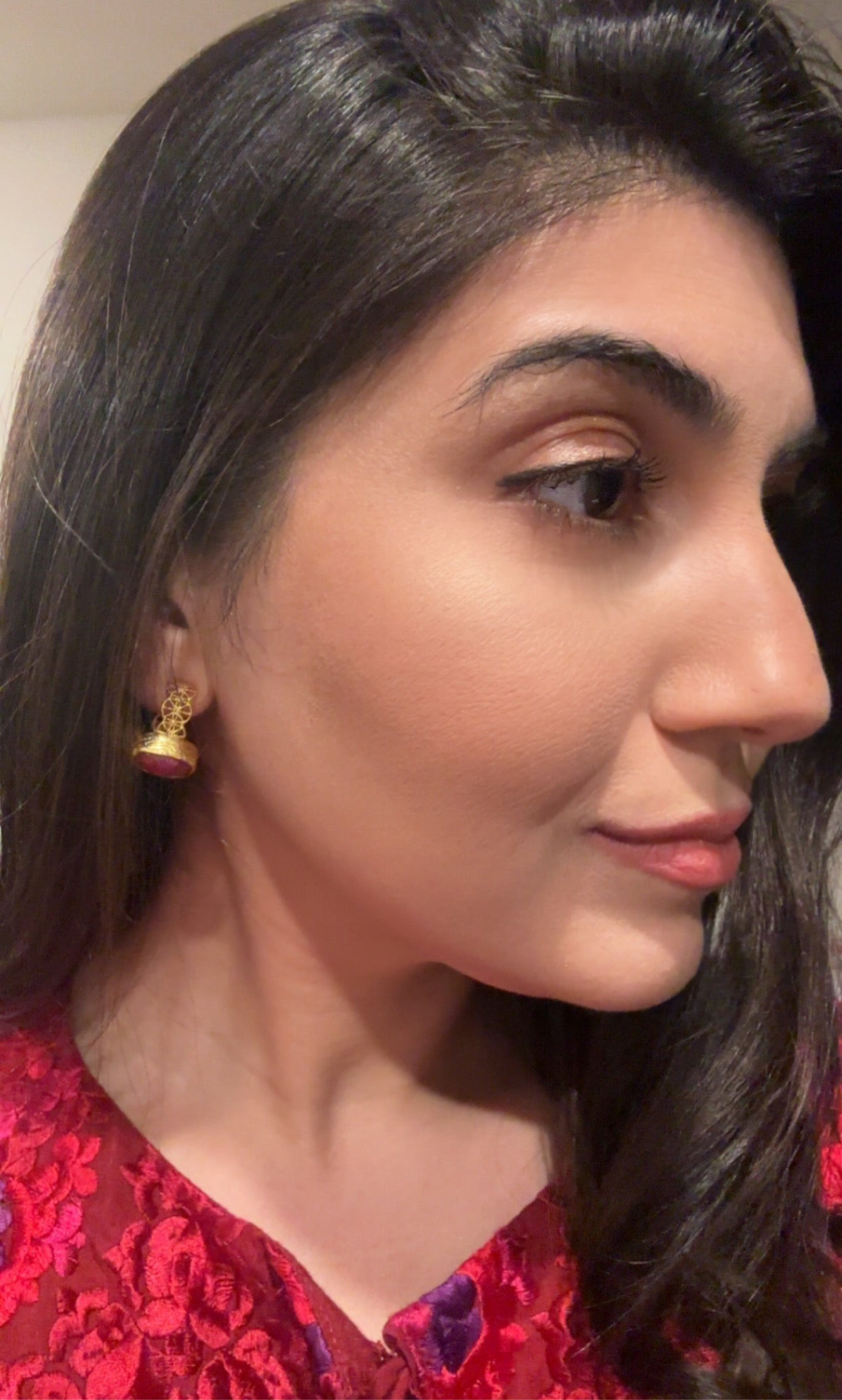 close up of woman wearing dainty gold-plated artisanal lace ruby hoop earrings 