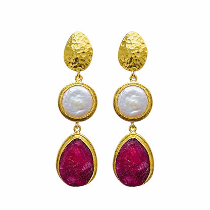 Elegant handmade gold-plated ruby and flat pearl dangle earrings arranged on a white surface 
