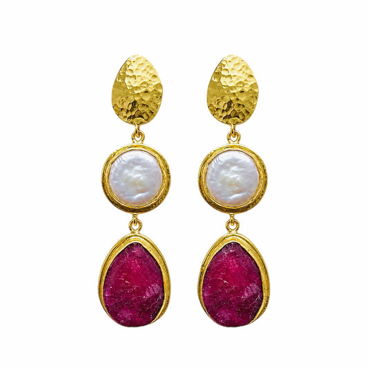 Elegant handmade gold-plated ruby and flat pearl dangle earrings arranged on a white surface 