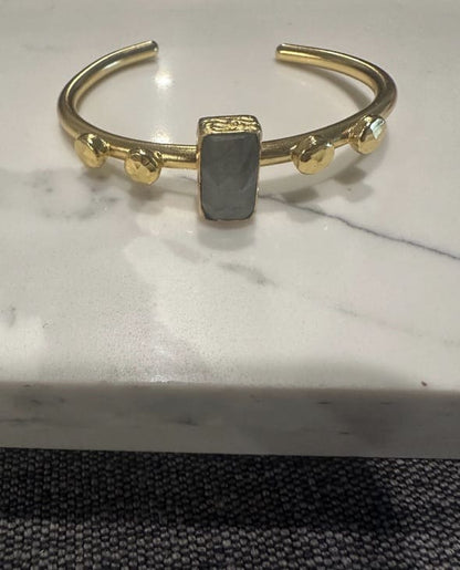 Sustainable Gold-plated artisanal bracelet with a central labradorite gemstone on a marble surface