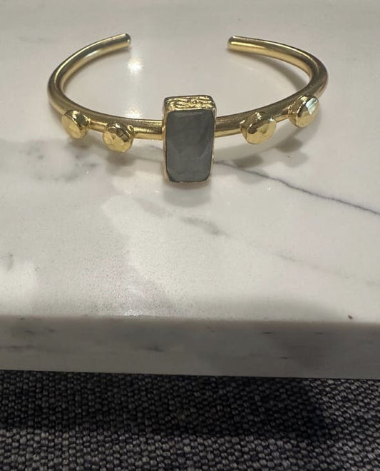 Sustainable Gold-plated artisanal bracelet with a central labradorite gemstone on a marble surface