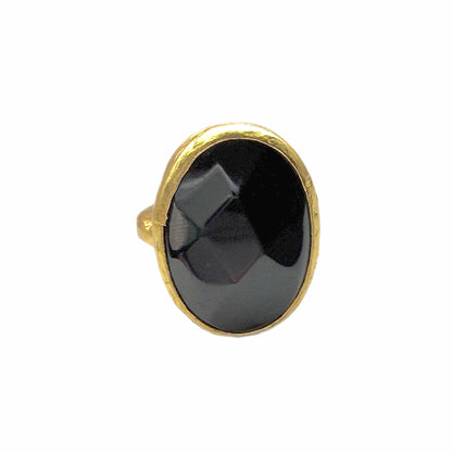 Front view of A textured handmade gold ring featuring a large, faceted onyx gemstone ring against a plain white background