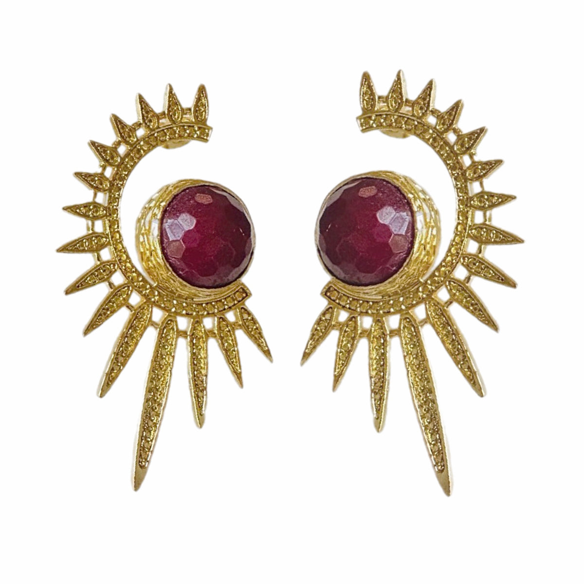 Gold plated contemporary starburst ruby statement earrings by Bebek jewels On white surface 