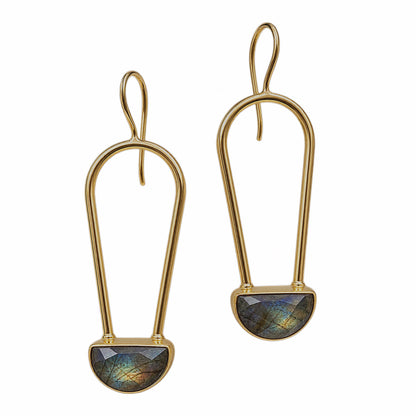 A pair of gold drop earrings with a teardrop-shaped gold frame and a faceted labradorite stone set in a semi-circular gold base, shown on a plain white background.