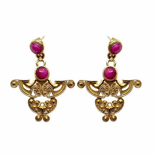 A pair of ornate gold-tone dangle earrings featuring round magenta-pink ruby gemstone accents, displayed against a solid white background.