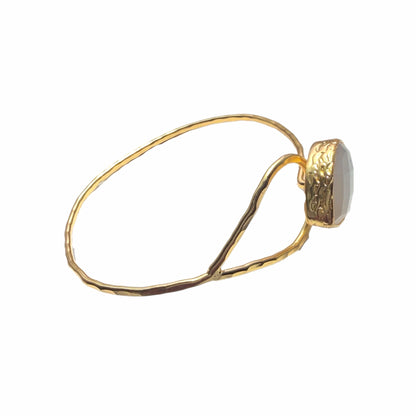 Gold-plated snow Quartz teardrop bracelet with a stone on a white background Facing right