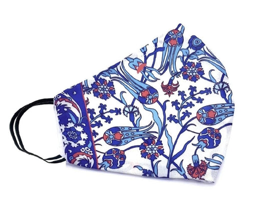 Handmade double-layered silk Iznik face mask in red, turquoise, blue and white on white surface