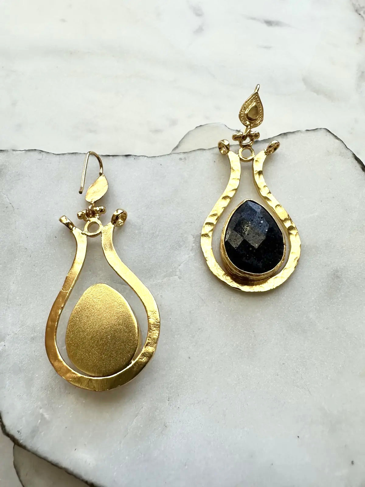 Gold-plated waterproof and lapis lazuli teardrop earrings on a marble surface