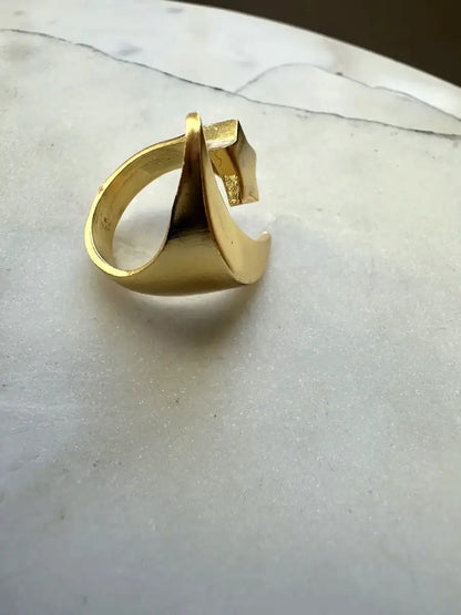 Handcrafted gold-plated moon and star ring on a marble surface